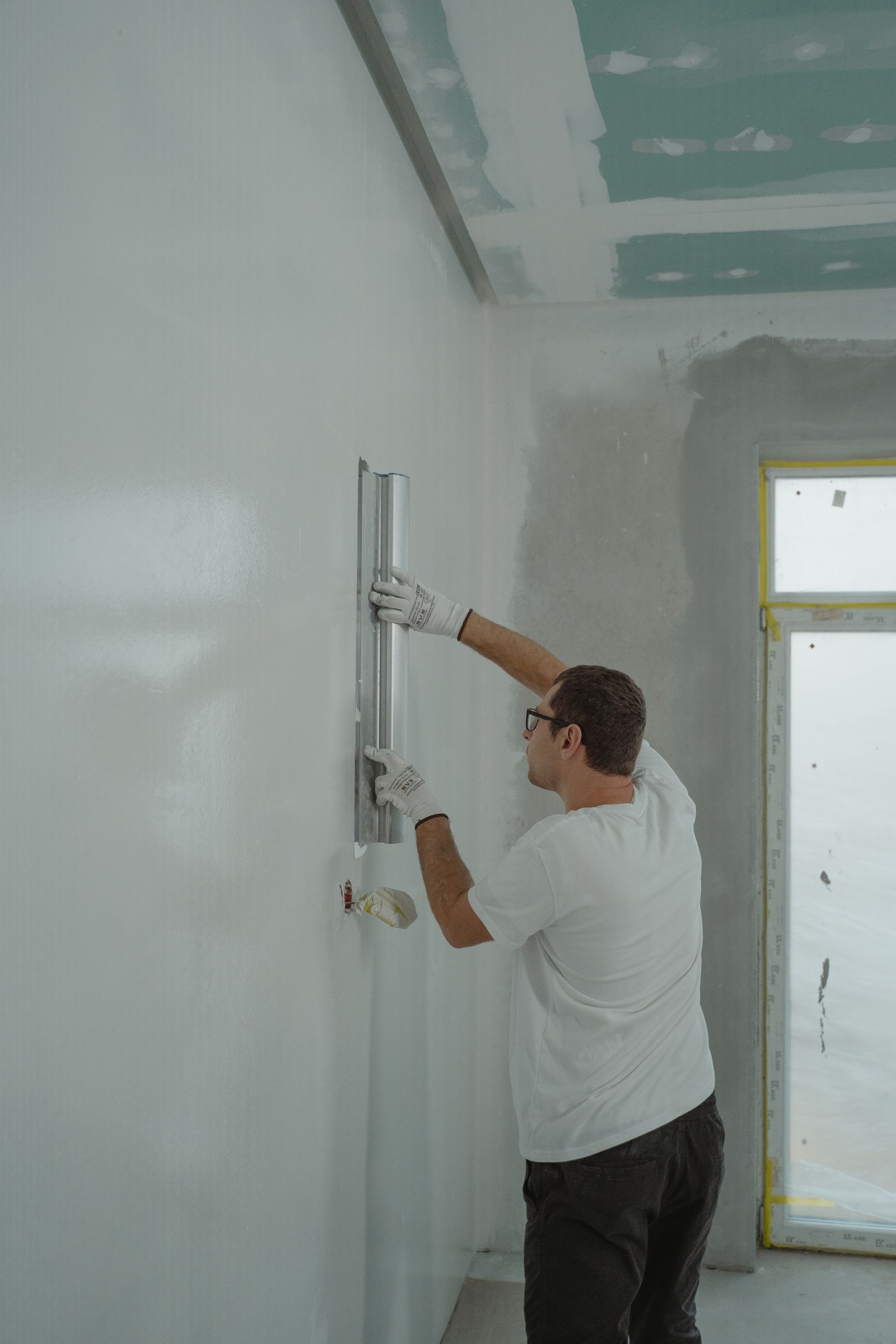 Drywall — Clean interior mid-remodel with new smooth drywall, taped and finished, natural light.