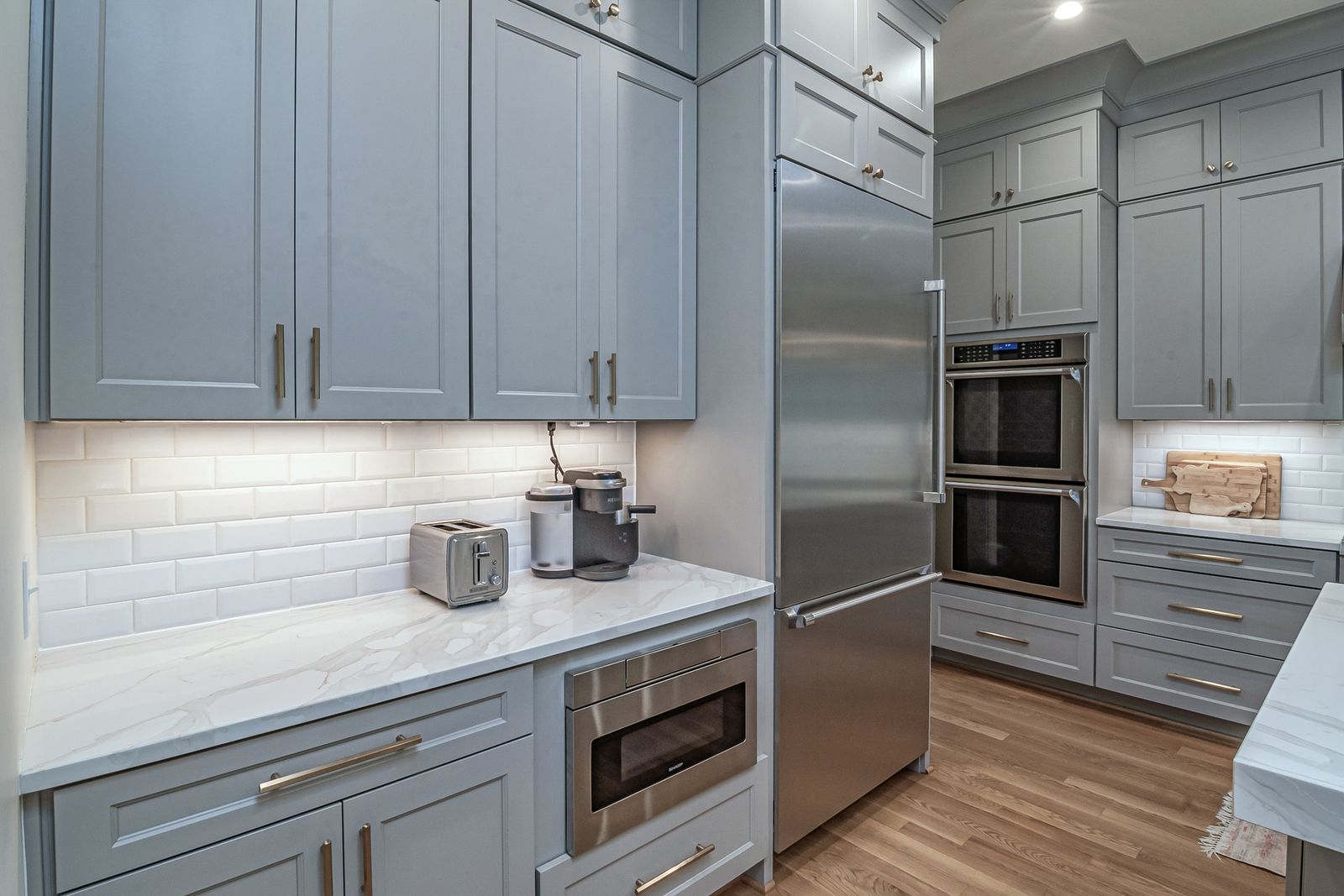 Signature kitchen remodel with shaker cabinets, marble counters and brass fixtures
